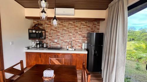 Il comprend une cuisine équipée d'une table et d'un réfrigérateur noir. dans l'établissement Villa Guarumo, à Santa Eulalia