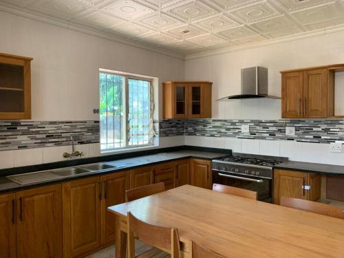 Una cocina con gabinetes de madera y una mesa de madera en ella. en Hazel Nest Ezulwini, en Ezulwini