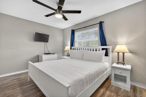 圣徒皮特海滩Sunset Beach Suites Unit 10的卧室配有白色的床和吊扇