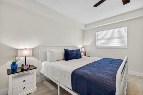 a bedroom with a bed with a blue bedspread and a nightstand at Sunset Beach Suites Unit 2 in St. Pete Beach