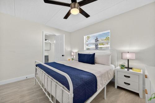 a white bedroom with a bed and a ceiling fan at Sunset Beach Suites Unit 1 in St. Pete Beach
