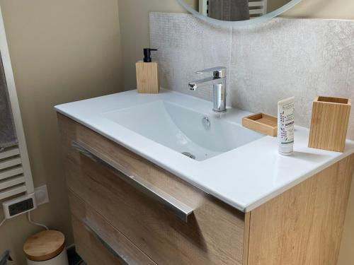 une salle de bains avec un lavabo blanc et un miroir dans l'établissement Gîte calme près de La Flèche, idéal pour familles - FR-1-410-479, à Mansigné