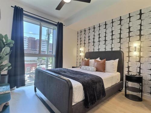 a bedroom with a bed and a large window at Cozy Downtown Spot, Gym, 5 min to Hospital) for field in Birmingham