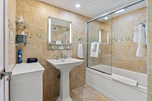 Un baño con lavabo, ducha y bañera. en 10th Floor Oceanfront with Spectacular Views Pool, en Myrtle Beach