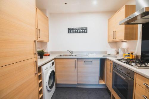 a kitchen with a washer and dryer in it at Top-Floor 2-Bed Near Braehead in Renfrew