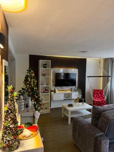 ein Wohnzimmer mit einem Weihnachtsbaum und einer Couch in der Unterkunft Apartamento a 10 minutos del aeropuerto de Bogotá in Bogotá