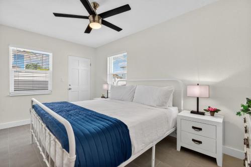 a white bedroom with a bed and a ceiling fan at Park Shores Suites Unit 9 in St Pete Beach