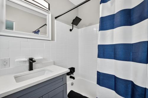 圣徒皮特海滩Park Shore Suites Unit 7的浴室设有水槽和蓝白色的浴帘