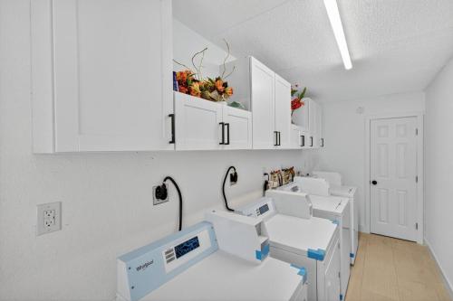 a row of sinks in a room with white cabinets at Sunset Beach Suites Unit 9 in St Pete Beach