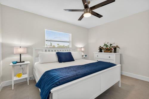 a bedroom with a white bed and a ceiling fan at Sunset Beach Suites Unit 9 in St Pete Beach