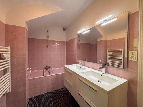 La salle de bains est pourvue d'un lavabo et d'une baignoire avec un miroir. dans l'établissement Maison de vacances avec grande piscine et tennis, proche du Zoo de Beauval et des Châteaux de la Loire - FR-1-591-47, à Villentrois