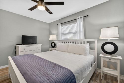 una camera da letto con un letto e un ventilatore a soffitto di Sunset Beach Suites Unit 8 a St Pete Beach