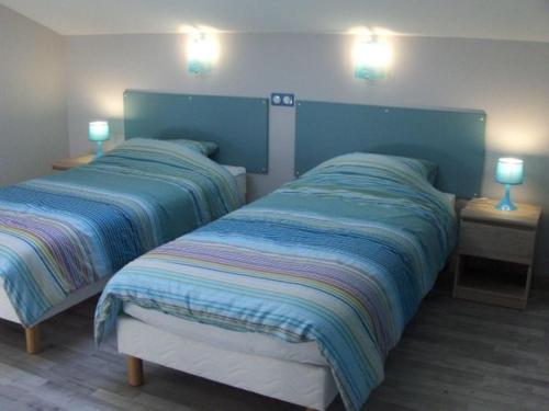 2 Betten in einem Schlafzimmer mit 2 Lampen an der Wand in der Unterkunft Gîte Contemporain en Écovillage avec Grande Terrasse et Proximité Attractions, 3 Chambres, PMR - FR-1-584-123 in Ville-sur-Yron