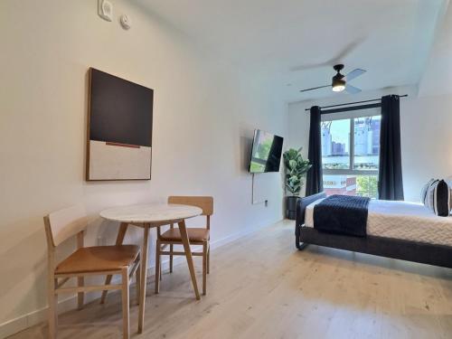 Un dormitorio con una cama y una mesa y sillas. en Chic Studio, Gym Access, Steps to Regions Field) for field, en Birmingham