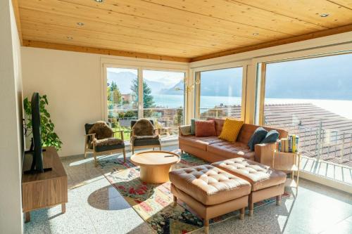 un soggiorno con un divano e un tavolo di Luxury Lakeview Chalet with AC & SPA near Interlaken a Niederried