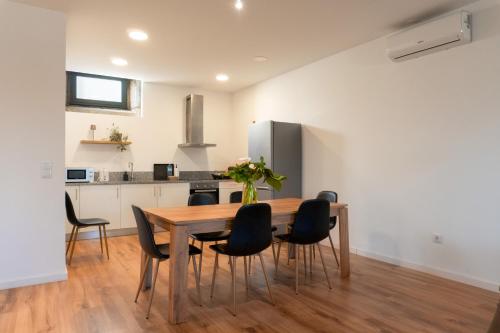 a kitchen and dining room with a wooden table and chairs at Casas de Fralães in Grimancelos