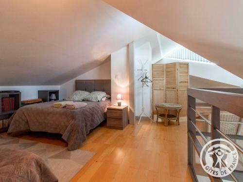 ein Schlafzimmer mit einem großen Bett im Dachgeschoss in der Unterkunft Gîte charmant avec jardin au cœur du vignoble du Layon, proche Saumur, 9 couchages, vélos inclus - FR-1-622-19 in Aubigné