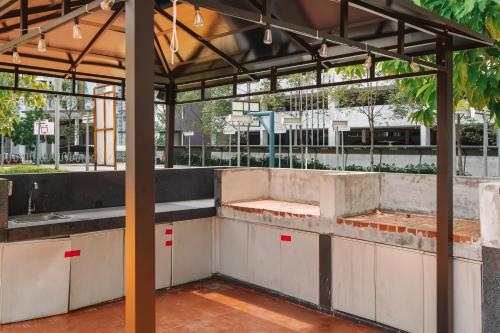 an outdoor kitchen in a building with a roof at The One by Nakza Stays, Lakeview Suites at Putrajaya in Putrajaya