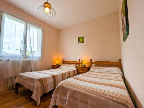 drei Betten in einem Zimmer mit Fenster in der Unterkunft Évasion en Berry: Maison proche Voie Verte, Château et Nature - idéal familles et pêcheurs - FR-1-591-55 in Chabenet