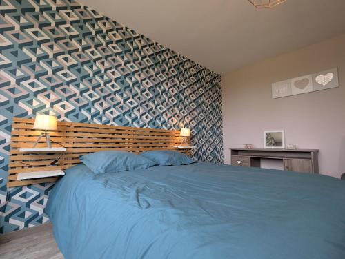 - une chambre avec un lit bleu et une tête de lit en bois dans l'établissement Charmante maison avec jardin, proche de George Sand, circuit auto, hippodrome, plans d'eau et nature. - FR-1-591-320, à Thevet-Saint-Julien