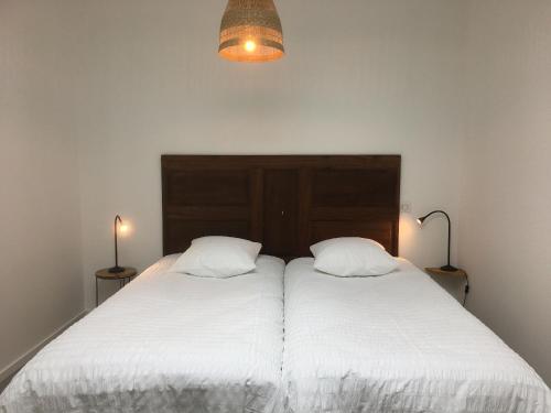 a bedroom with two beds with white sheets and two lamps at Gîte rénové, 35 min de Nancy, près de châteaux, fibre, parking privé, idéal famille - FR-1-584-169 in Vroncourt