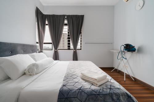 ein Schlafzimmer mit einem Bett mit weißen Laken und einem Fenster in der Unterkunft The One by Nakza Stays, Lakeview Suites at Putrajaya in Putrajaya