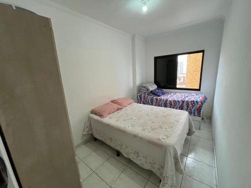 a small room with a bed and a tv at Apartamento Praia Grande 300 m da praia in Praia Grande