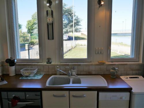 a kitchen counter with a sink and two windows at Charmante Maison pour 6 à St Père-sur-Loire, Vue Loire - FR-1-590-178 in Saint-Père-sur-Loire