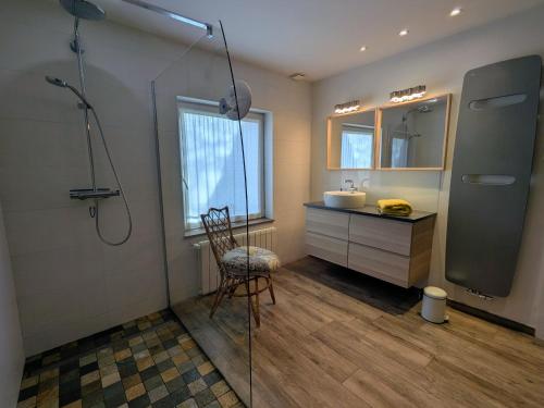 a bathroom with a shower and a sink and a chair at Maison cosy à Gérardmer avec 2 chambres et terrasse ensoleillée, proche activités - FR-1-589-110 in Gérardmer