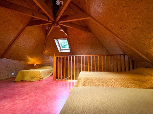 a attic room with two beds and a window at Chalet en pleine nature à Orsennes avec étang à proximité, idéal pour 6 personnes et animaux admis - FR-1-591-170 in Orsennes