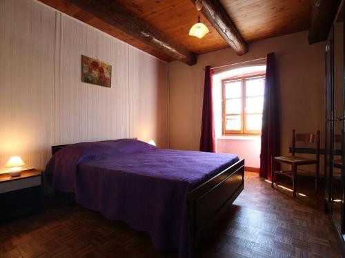 une chambre avec un lit violet et une fenêtre dans l'établissement Gîte indépendant avec cour privative près de Lavoute-Chilhac et Langeac - FR-1-582-224, à Ferrussac