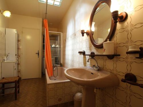 une salle de bains avec lavabo, miroir et baignoire dans l'établissement Ferme du XIXe avec cheminée, près des gorges du Doulon - FR-1-582-227, à Frugières-le-Pin