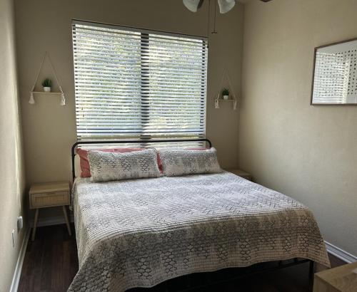Un dormitorio con una cama frente a una ventana. en Minutes to UTA, AT&T Stadium, Globe Life Field, en Arlington