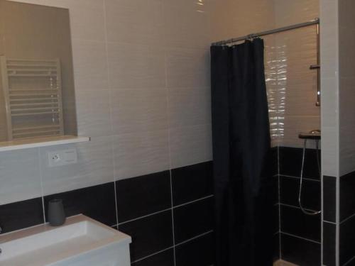 a bathroom with a black shower curtain and a sink at Gîte de charme avec WiFi dans ancienne ferme - FR-1-426-457 in Falleron