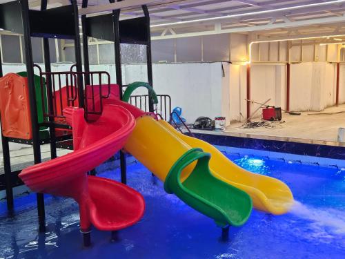 - une aire de jeux avec des toboggans colorés dans une piscine dans l'établissement Royal Pearl Sea View فيلا اللؤلؤة الملكية اطلالة بحرية, à Djeddah