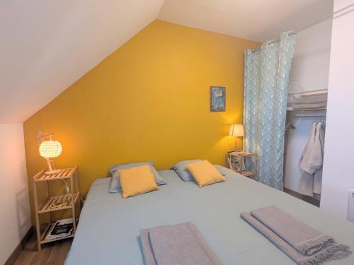 a bedroom with a bed with a yellow wall at Maison typique en Berry avec jardin privatif, BBQ et parking - FR-1-591-598 in Thenay
