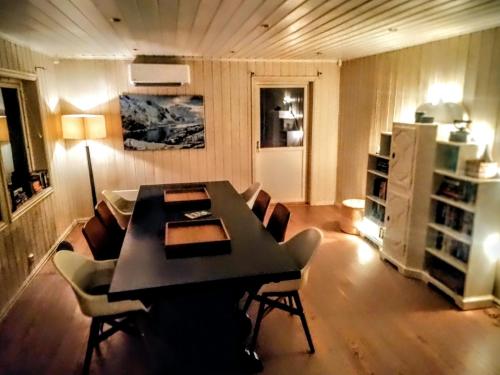 ein Esszimmer mit einem schwarzen Tisch und Stühlen in der Unterkunft Skap Opplevelser! in Svingvoll
