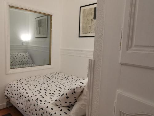 a small bedroom with a mirror and a bed at Cocon au cœur du Puy-en-Velay avec cour privée et WIFI - FR-1-582-325 in Le Puy en Velay