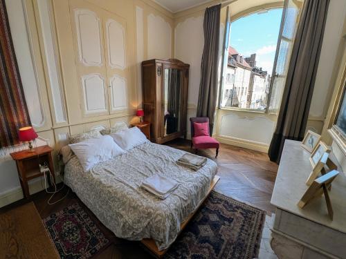 a bedroom with a bed and a large window at Appartement charmant au cœur de Vesoul avec parking privé - FR-1-583-509 in Vesoul