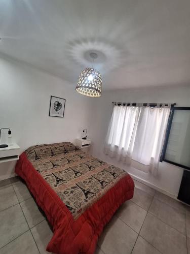 a bedroom with a bed and a chandelier at Casa Clara in Tandil