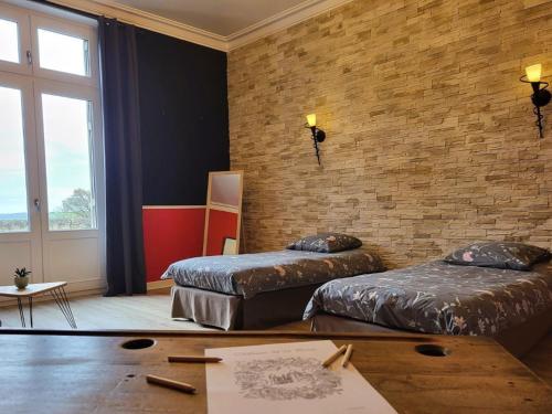 a room with two beds and a brick wall at Suite Familiale au Château avec Balcon sur Parc - FR-1-591-767 in Cluis
