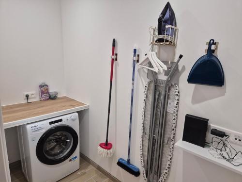 une buanderie avec des gants et une machine à laver dans l'établissement Maison Au Beau Regard, à Belleu