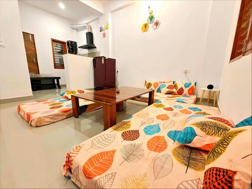 Zimmer mit 2 Betten und einem Holztisch in der Unterkunft A2 Vista - 4BHK Villa with Lawn Near Expo Mart in Greater Noida