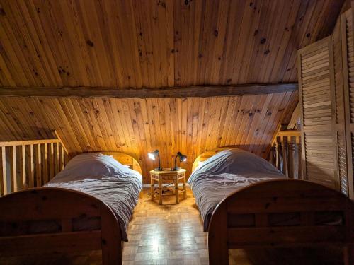 a bedroom with two beds in a wooden room at Gîte calme en forêt, proche Gien, 3 chambres et 2 salles d'eau - FR-1-590-555 in Ouzouer-sur-Trézée