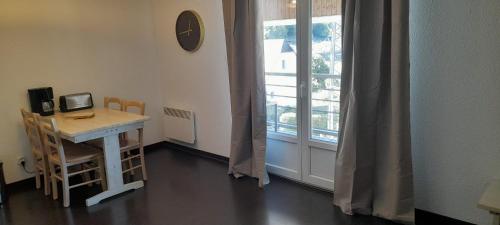 ein Zimmer mit einem Schreibtisch und einem Fenster mit einem Tisch und Stühlen in der Unterkunft Appartement cosy Luz-St-Sauveur Ski et randonnée in Luz-Saint-Sauveur