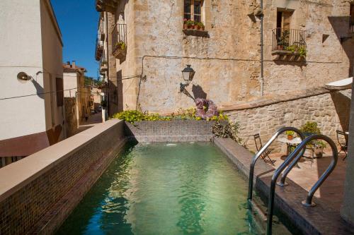 
a swimming pool with a waterfall in the middle of it at Hotel del Sitjar in Calaceite
