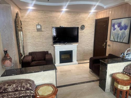 a living room with a fireplace and a flat screen tv at Abu Issa Hostel Tangier in Tangier