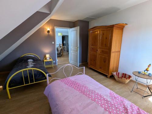 ein Schlafzimmer mit einem rosa Bett und einem Dachboden in der Unterkunft Gîte spacieux à Fretigney avec jardin et billard, idéal pour 8 pers. - FR-1-583-507 in Frétigney-et-Velloreille