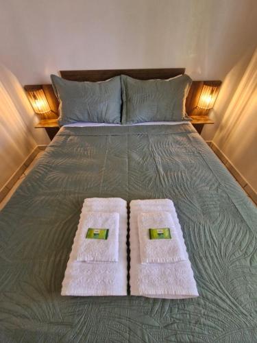 a bed with two towels on top of it at Recanto Bamboo Verde in Torres