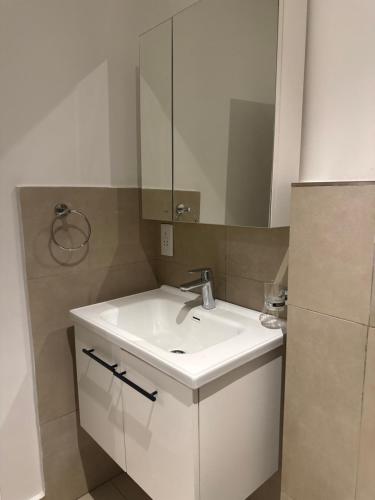 a bathroom with a white sink and a mirror at Executive studio at East Legon in Accra